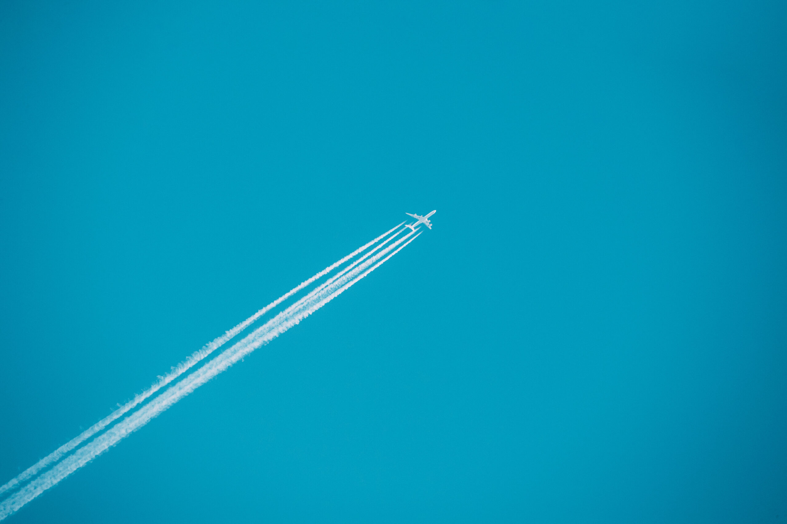 Contrail In Blue Sky. Plane, Clear Sunny Sky Background. Airplane Aircraft In Sky With Plane Trails